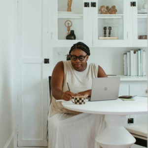 A woman working a laptop in her home